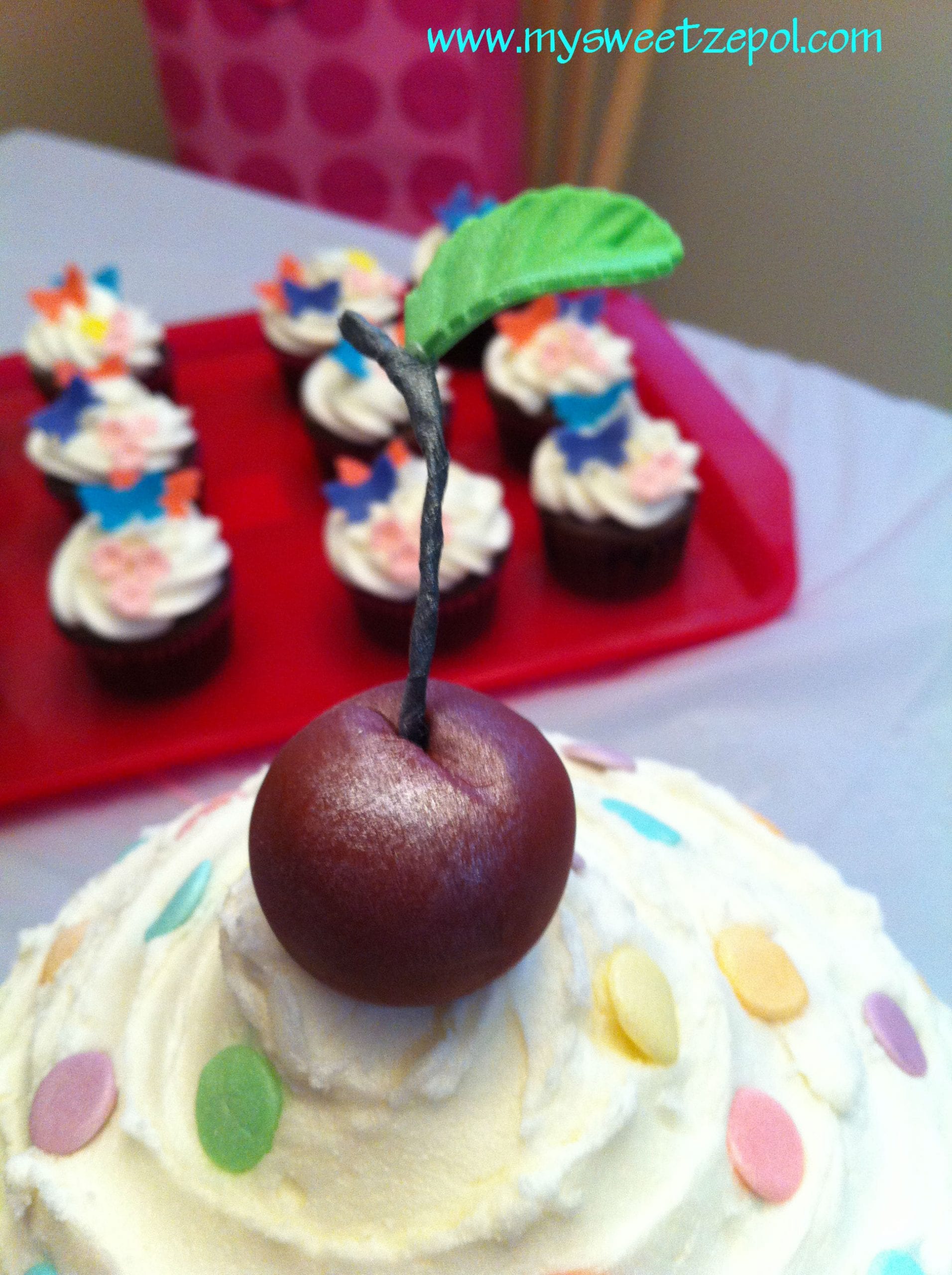 Cherry close-up on a big cupcake birthday cake