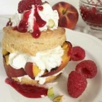 Grilled Peach Shortcake drizzled with Raspberry Sauce and Pistachios
