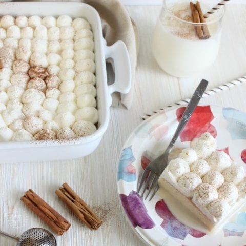 horchata tres leches cake made with Horchata milk and selved with a cold glass of horchata milk garnished with cinnamon sticks