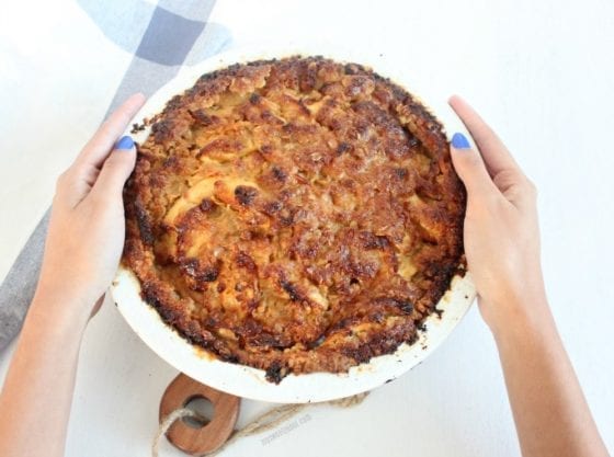 Here's a beautiful Apple Caramel Crumb Pie with hands in picture and a kitchen towel to add more of that blue color from the nails. Perfect #EasterSweeksWeek treat grab the recipe at mysweetzepol.com #ad
