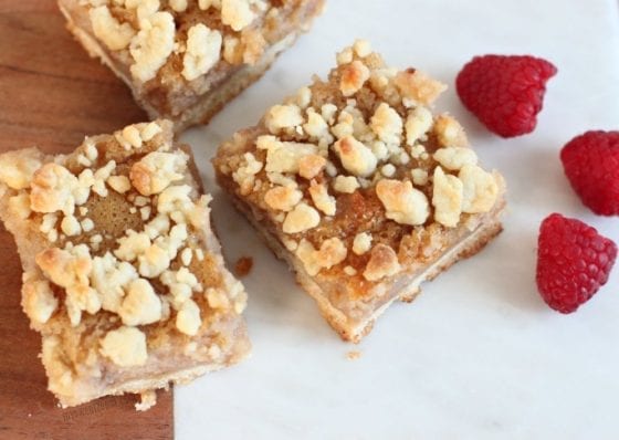 Pink Lemonade Crumb Bars served on a wooden and marble board with fresh raspberries. The best dessert to welcome Spring. Grab the recipe at mysweetzepol.com #EasterSweetsWeek #ad