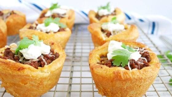 BBQ-Beef-Croissant-Cups in a plate with cilatro, a dollop of sour cream, and melted cheese