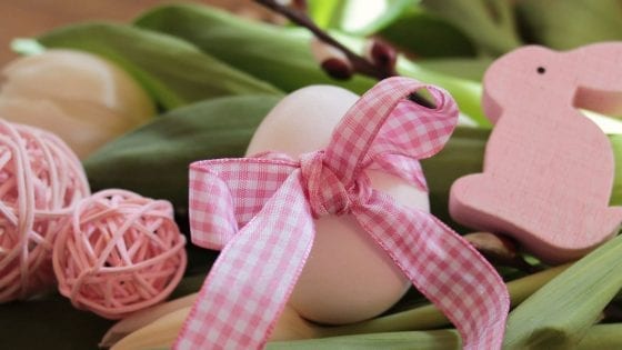 Easter egg with pink ribbon and green grass