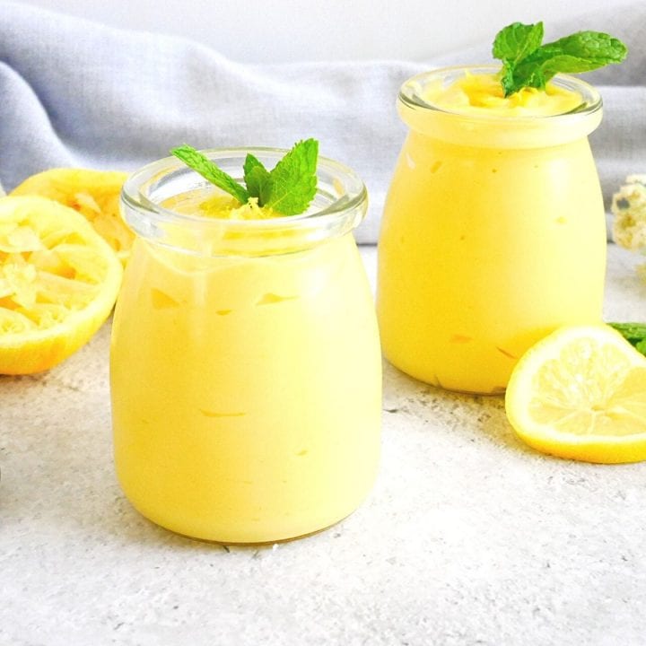 lemon curd with lemons, mint leaves, spoons and kitchen towels